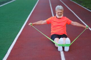 elderly man exercises with resistance band for weight loss program