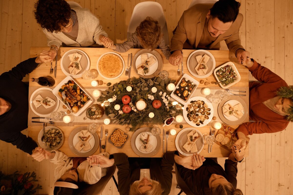 family-gathers-around-the-table-for-holiday-dinner-party-1200x800.jpg