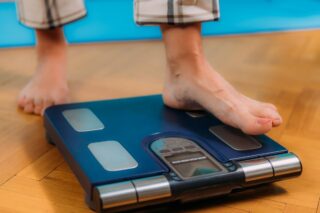 Person steps on recommended body composition analysis scale