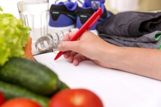 patient writes in food journal as part of weight management plan
