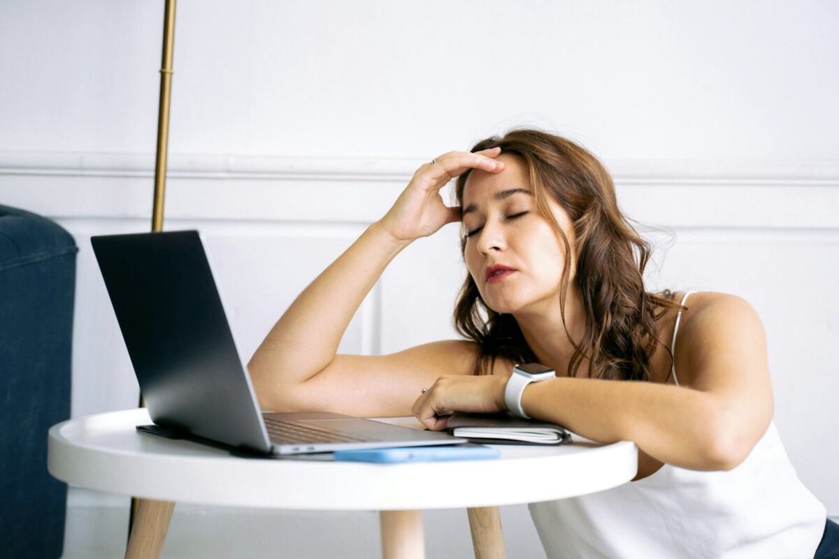 A woman struggles with a headache, a common sugar withdrawal symptom